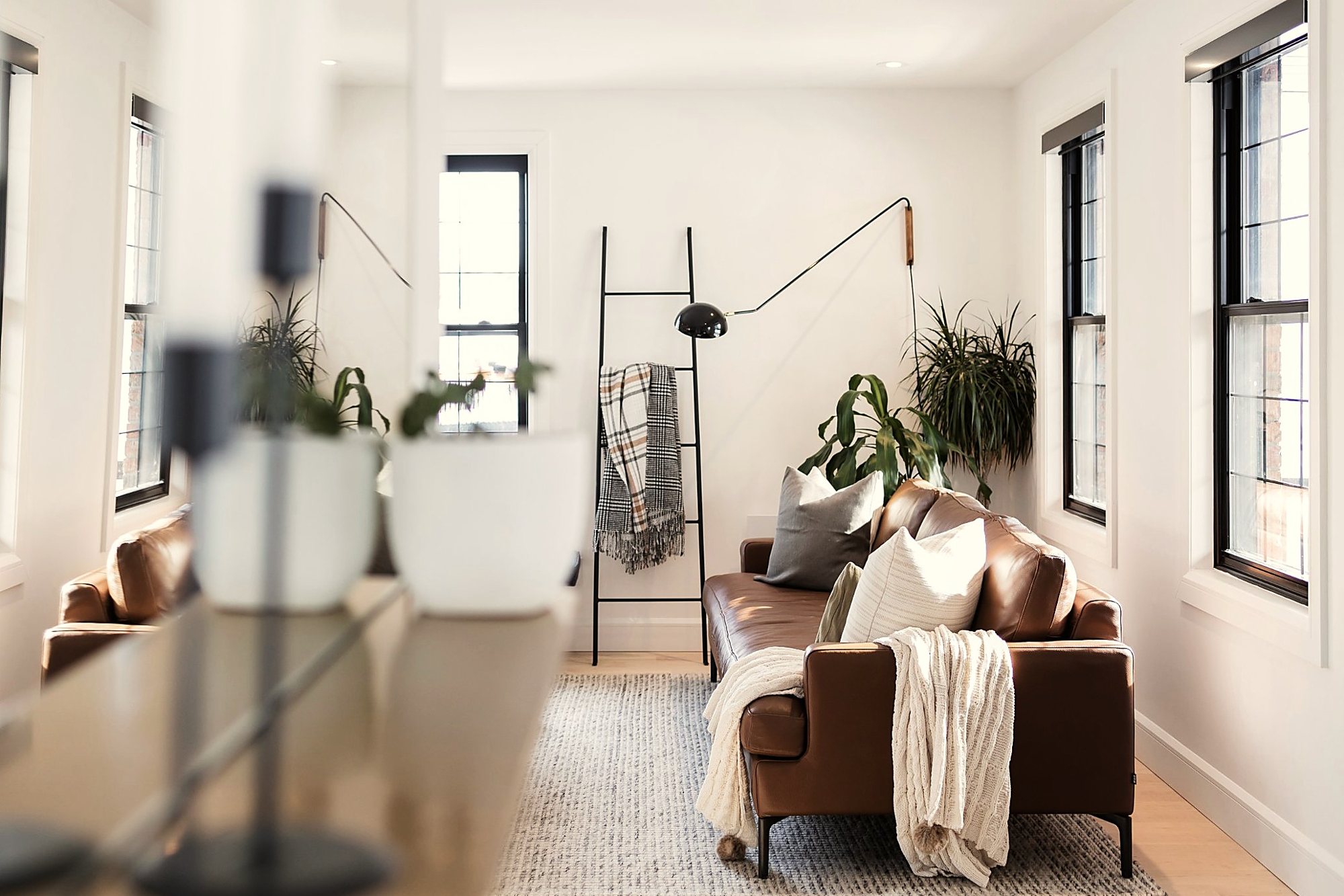 Salon lumineux avec sofa en cuir et grandes fenêtres, projet RDP