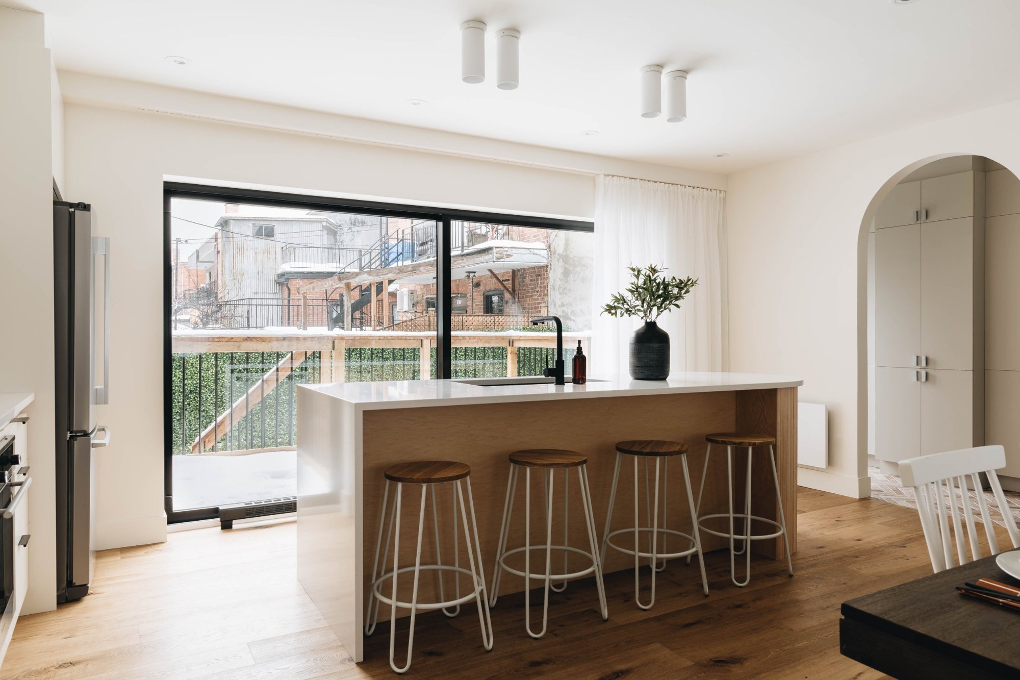 Cuisine avec îlot en bois et grande porte-fenêtre