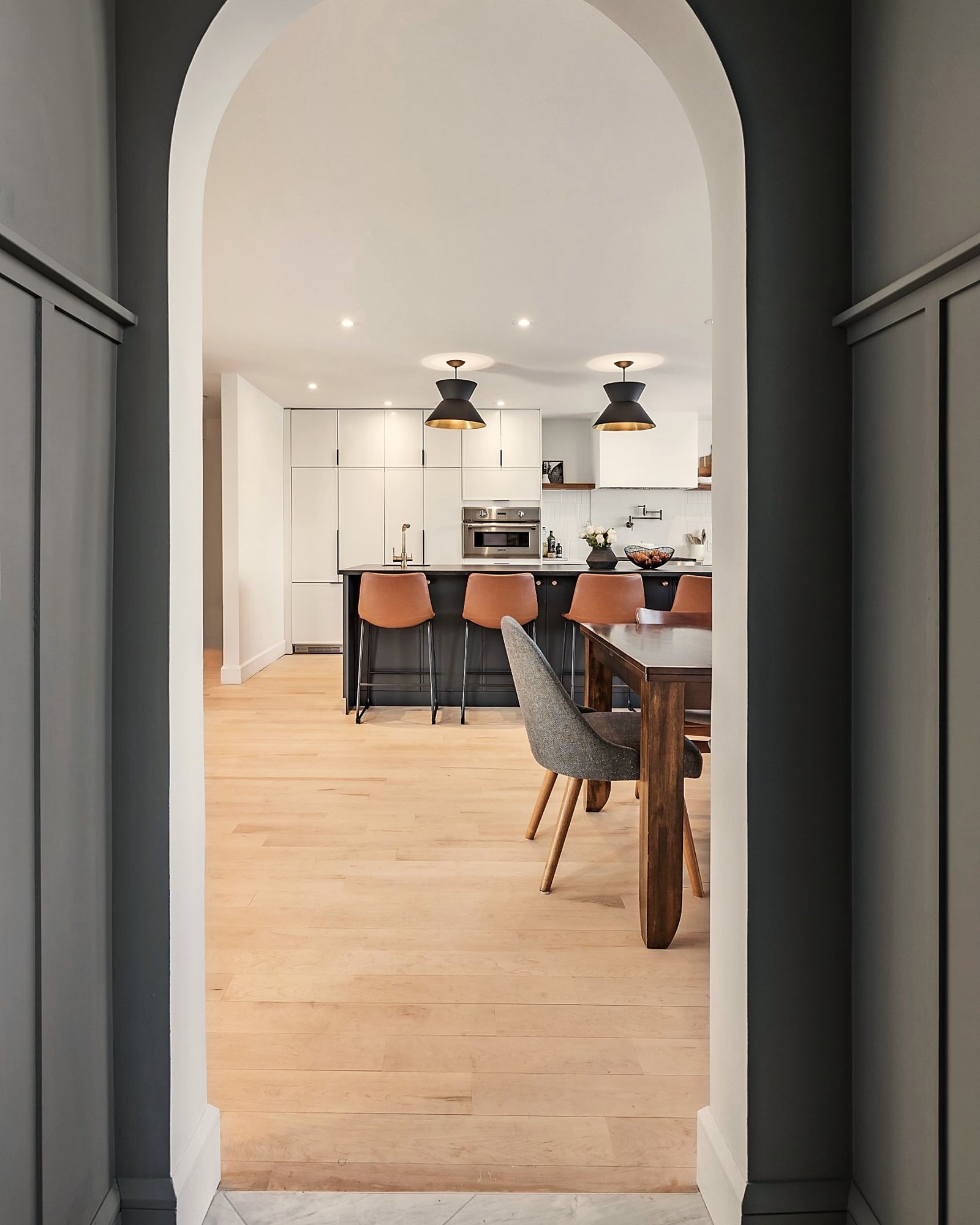 Arche ouvrant sur une cuisine avec îlot noir